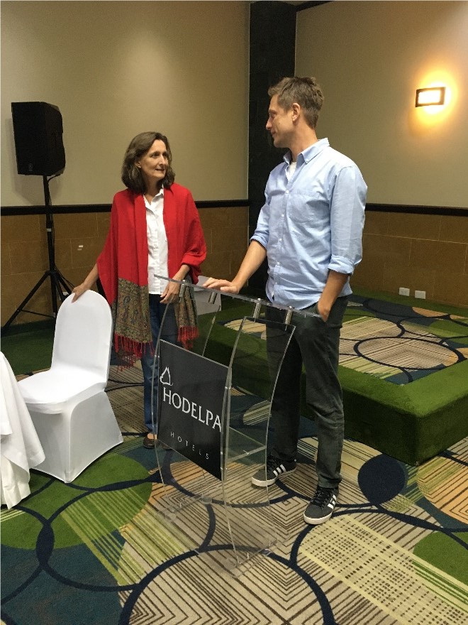Photo of Koen Voorend standing and speaking to Marike de Pe&ntilde;a, president of CLAC, in conference room